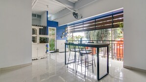 Eine moderne Küche mit Essbereich, ausgestattet mit einem weißen Schrank, einer Glastür und Blick ins Freie.