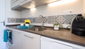 Een koelkast, een oven, een kookplaat, een koffiezetapparaat/waterkoker