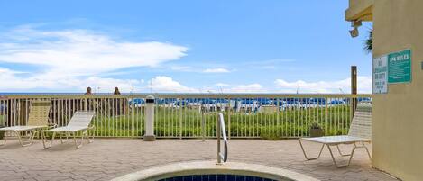 Een wellnessruimte met een jacuzzi, lounge fauteuils en uitzicht op het strand.