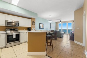 A modern kitchen with stainless steel appliances, a central island, and a dining area with a view.