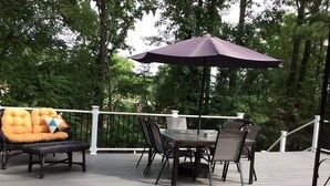 Eine Terrasse im Freien mit Tisch und Stühlen, umgeben von einem weißen Geländer.