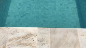 A swimming pool with a tiled floor and a tiled border. - Apart Sol Nascente (Itatiaia)