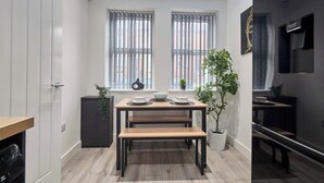 Eine moderne Küche mit Esstisch, zwei Bänken und einem Blumentopf.