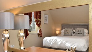 A hotel room with a bed, bedside lamps, a mirror, and a window with curtains. - Inchmurrin Lodge with private hot tub (Drymen)