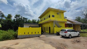 Un immeuble jaune à deux étages, avec un escalier menant à l’étage supérieur.