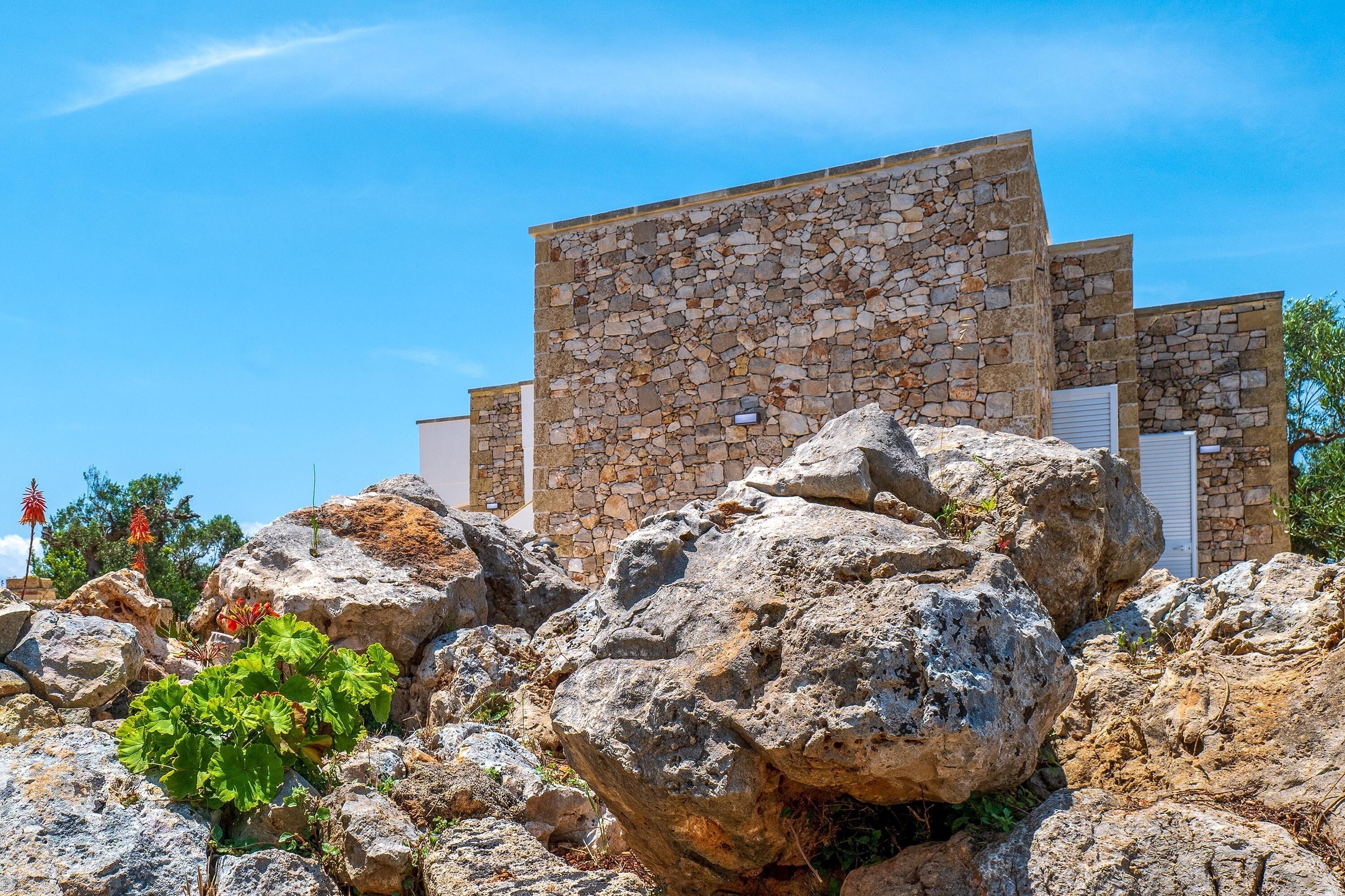 A stone building with a flat roof and a white door.
