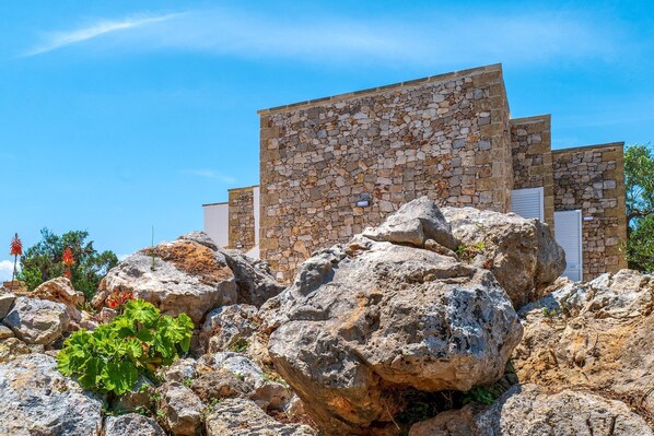 A stone building with a flat roof and a white door.