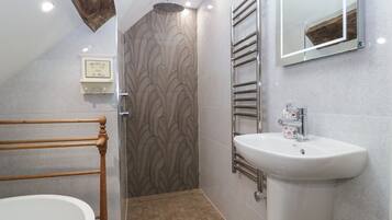 Un baño moderno con ducha, lavamanos y bañera de madera.