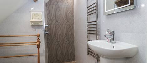 Ein modernes Badezimmer mit Dusche, Waschbecken und einer Holzwanne.