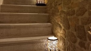 Eine Steintreppe mit einer Tür oben und einem Kerzenhalter unten.