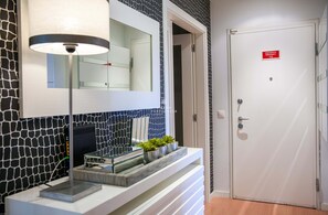 A modern bathroom with a mirror, a white door, and a sign indicating an emergency exit. - Apartment  Vilamoura Pine by D'Alma Portuguesa (Vilamoura)