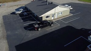 A parking lot with a building that has a flat roof and a single-story structure.