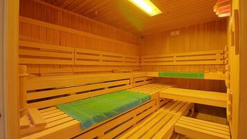 A sauna with wooden benches and a green towel.