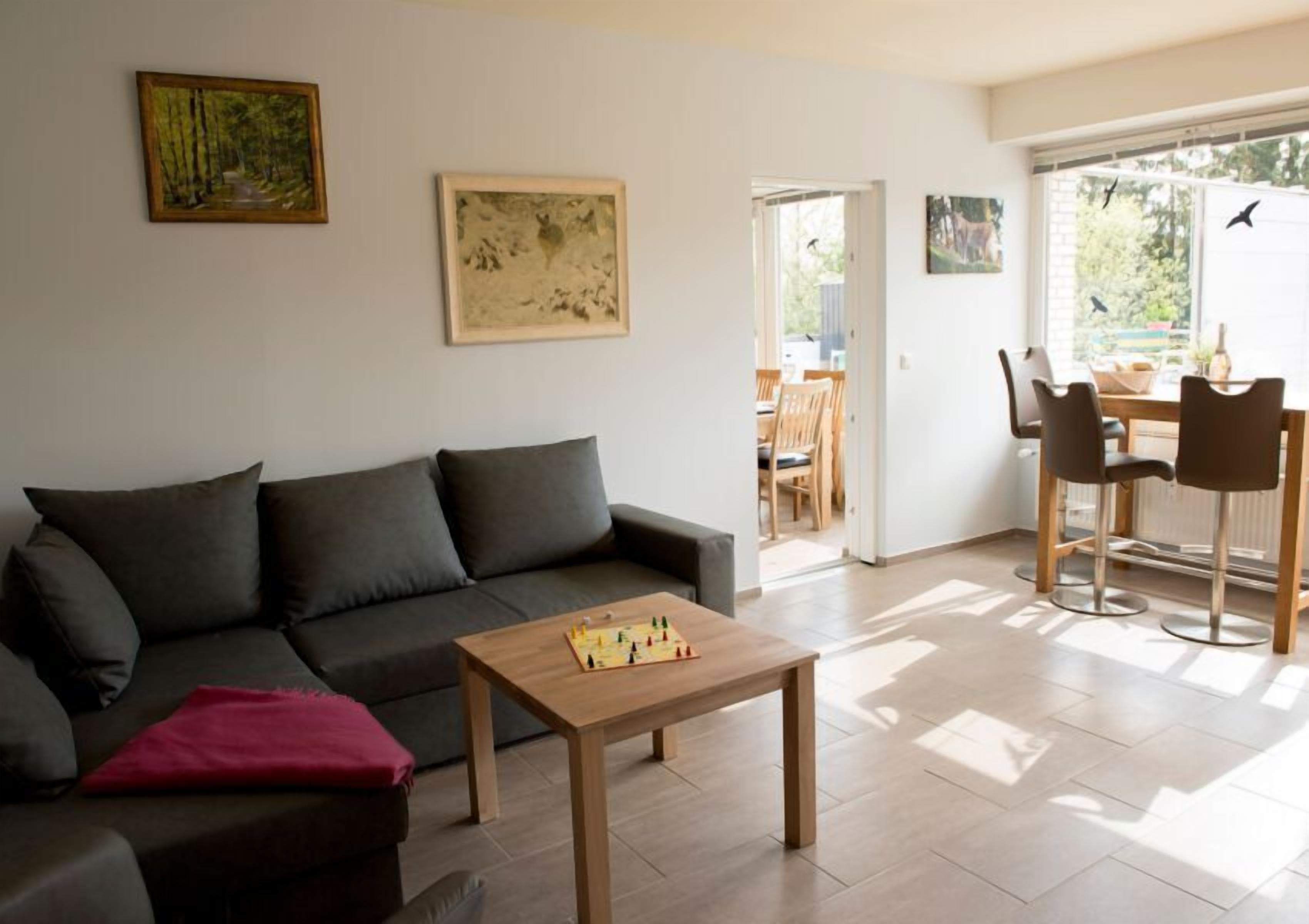 A living room with a dark grey sofa, a wooden coffee table, and a painting on the wall.