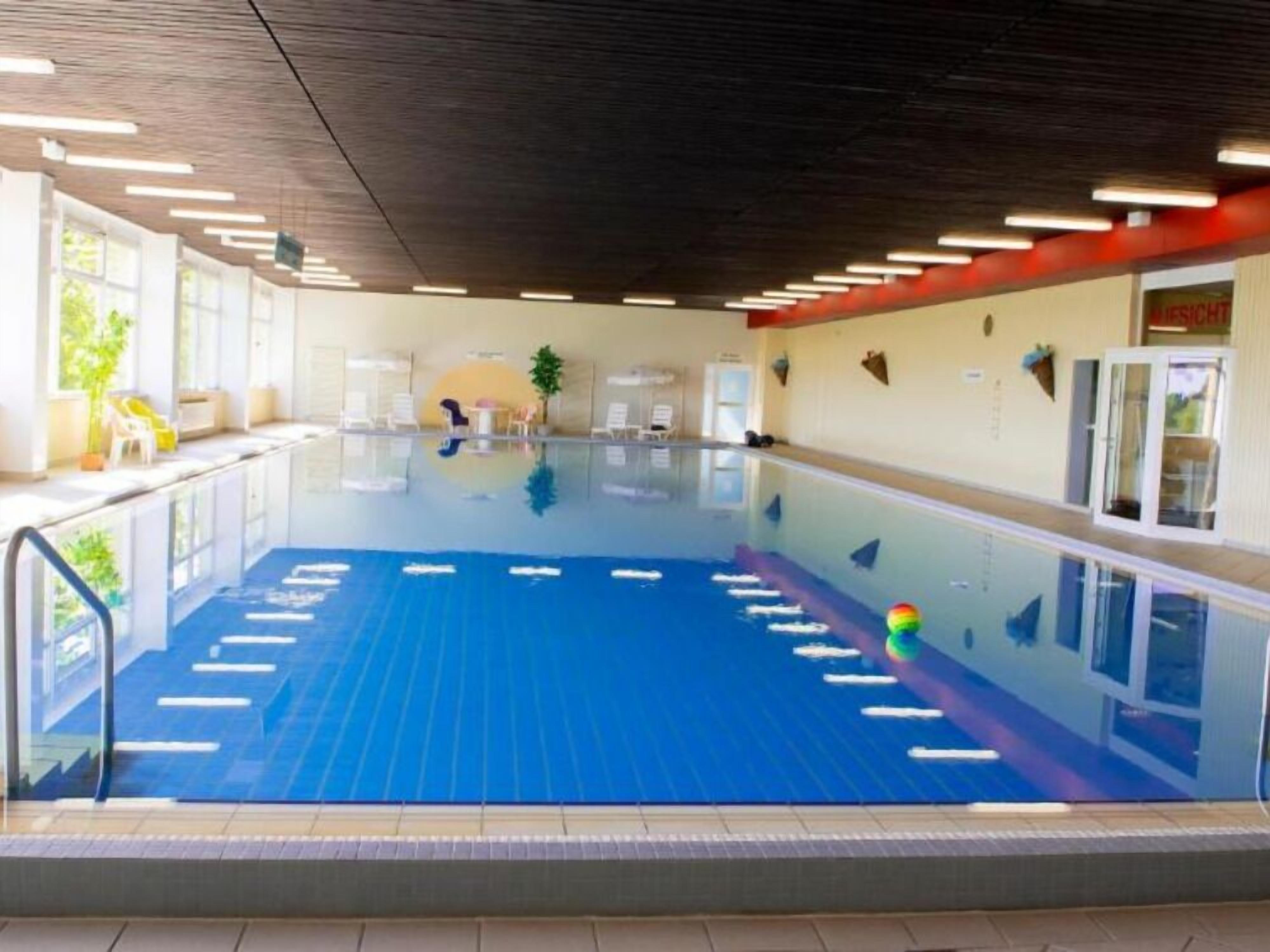 Ein Hallenbad mit deutlichen Bahnen, einem Umkleidebereich und einer Rezeption.