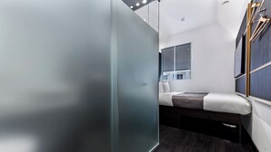 A modern, compact room with a bed, a window, and a mirror. - The Z Hotel Trafalgar (London)