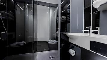 Une salle de bain moderne avec une douche à parois de verre, un lavabo blanc et un porte-serviettes.