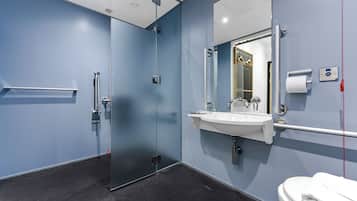 Un bagno moderno con box doccia in vetro, un lavandino bianco e un water.