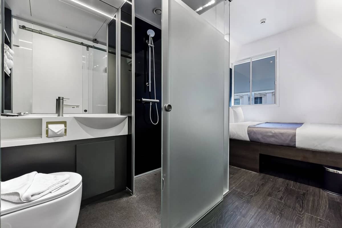 Une salle de bain moderne avec une douche à parois de verre, un lavabo et des toilettes.