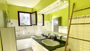 A kitchen with two sinks, a window, and a mirror.