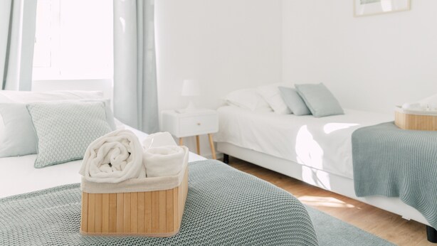 A modern bedroom with a wooden headboard, a bedside table, and a bed with a green blanket. - Oporto Yellow Villas   (Porto)