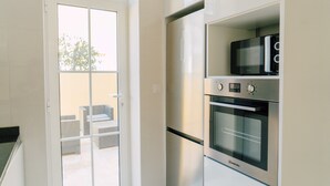 A kitchen with a built-in microwave, oven, and refrigerator. - Oporto Yellow Villas   (Porto)