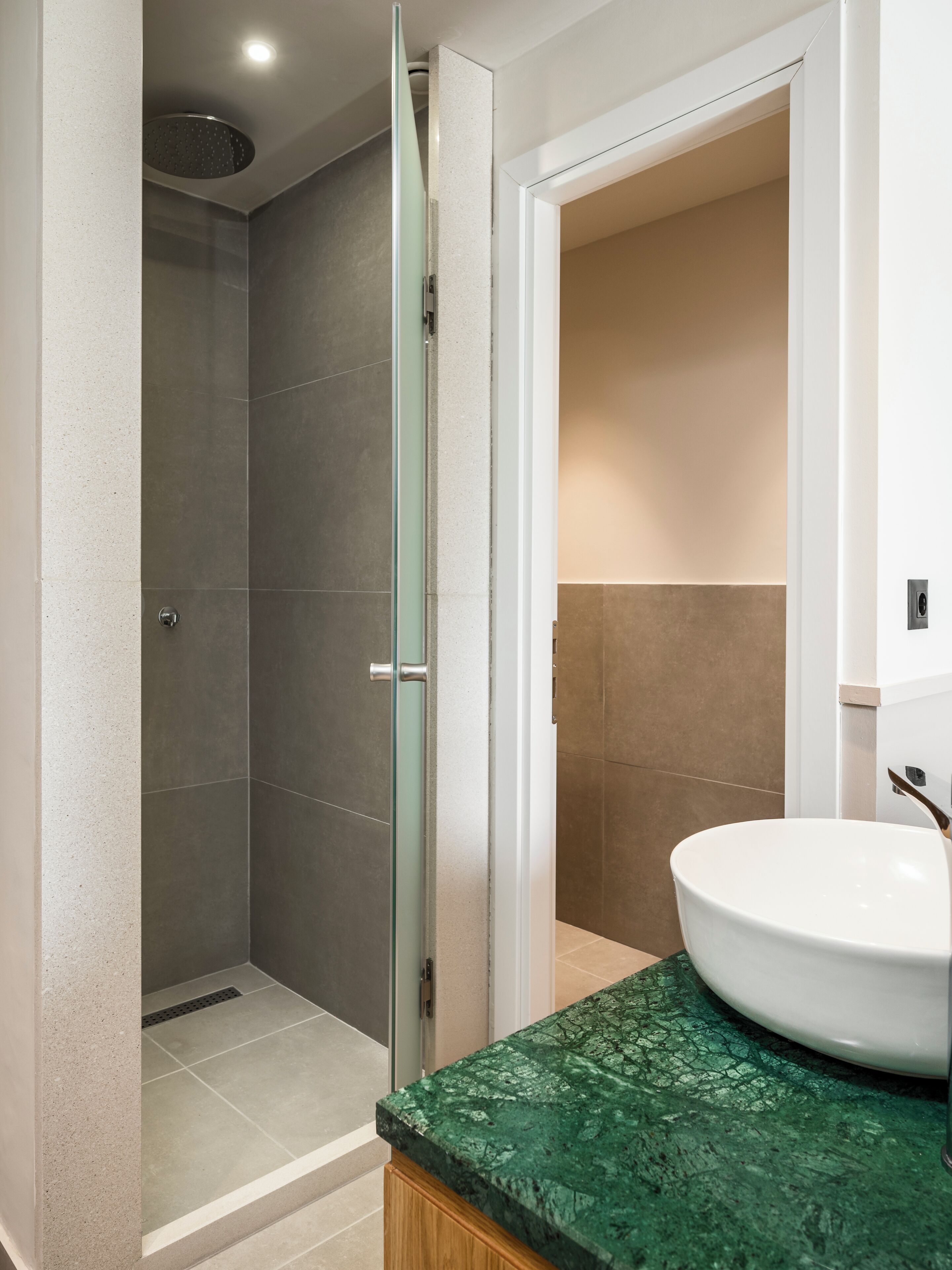 Un baño con ducha, lavabo y espejo.