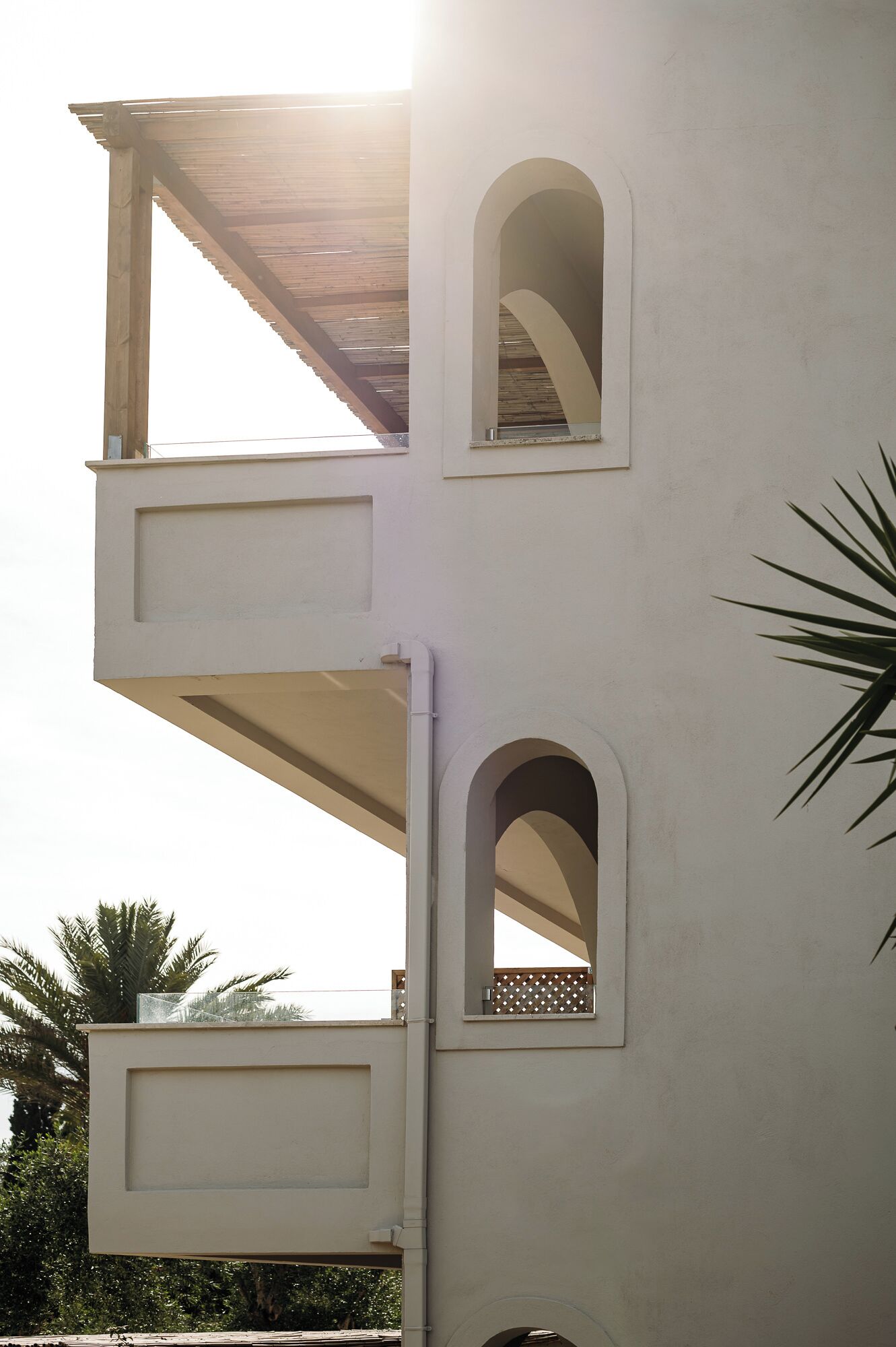 A building with a balcony and two arched windows.