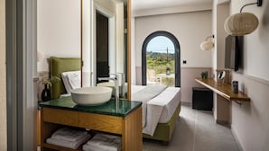 A modern bathroom with a large mirror, a bowl sink, a green towel, and a view of the outdoors. - Loadstar Rooms & Suites  (Corfu)