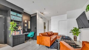 Uma sala de estar moderna com um sofá seccional, uma mesa de centro e uma estante.