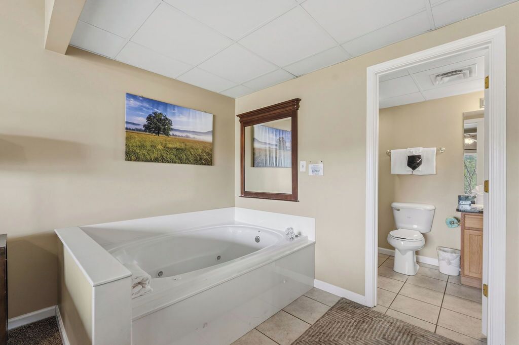 Ein Badezimmer mit einer großen Badewanne, Toilette und einer Duschkabine.