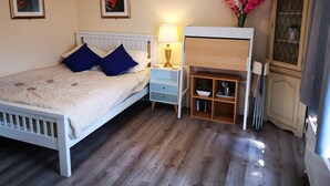 A bedroom with a bed, bedside tables, a lamp, a dresser, and a mirror. - Impeccable 1-bed Lodge in Eastleigh (Eastleigh)