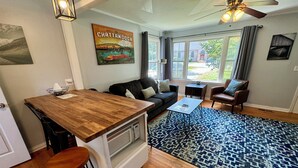 Un espacio habitable compacto con kitchenette, zona de comedor, sofá y mesa de centro.