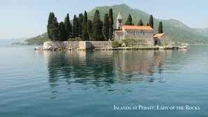 A stone church with a red roof on an island, surrounded by calm water and greenery. - Lavender Bay Resort, 4 person 75 m2 Apartment G8, Morinj, Montenegro (Morinj)
