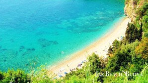 A coastal beach with clear turquoise waters, a sandy shore, and lush greenery. - Lavender Bay Resort, 4 person 75 m2 Apartment G8, Morinj, Montenegro (Morinj)