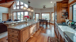 Una cocina amplia con armarios de madera, una isla grande y una zona de comedor con mesa y sillas.