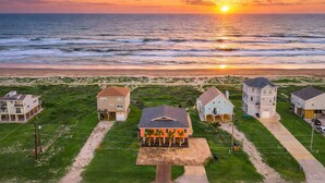 A beachfront property with multiple houses, a sandy beach, and the ocean.