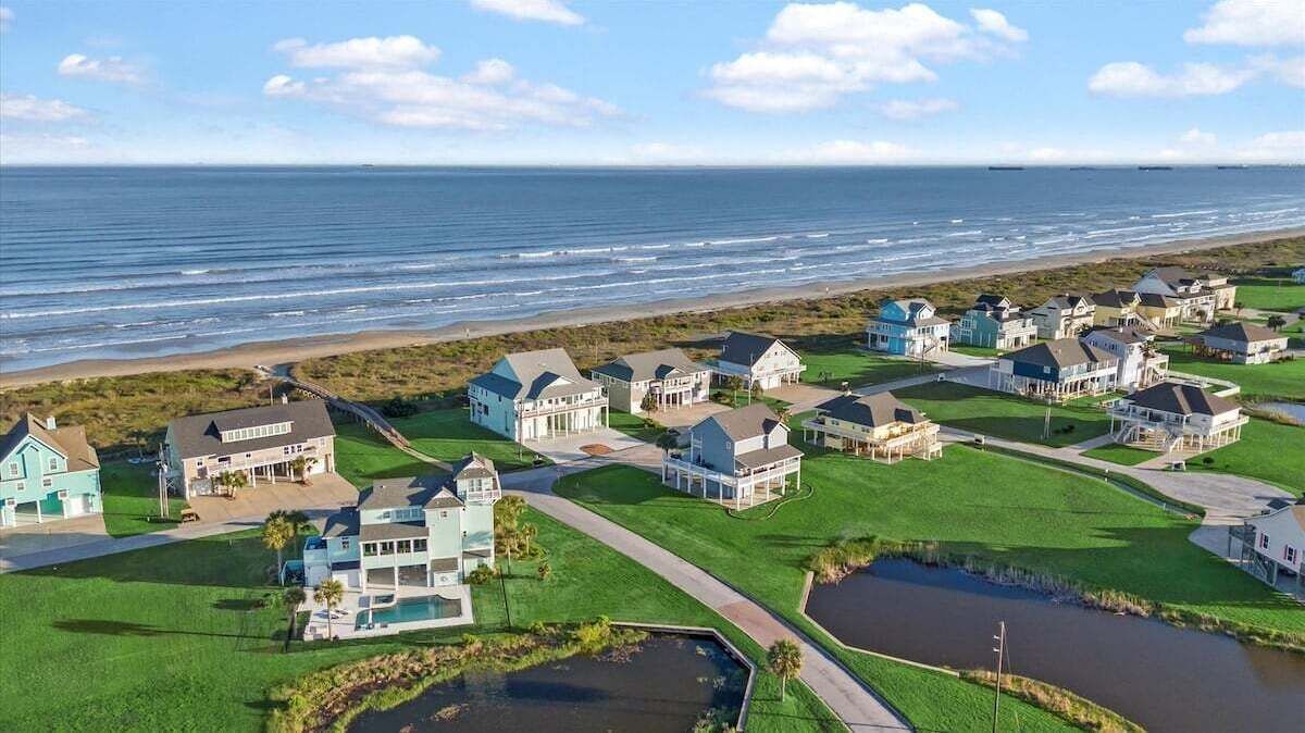 Une zone résidentielle côtière comprenant des maisons, une plage et un terrain de golf.