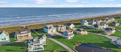 Zona residencial costera con casas, una playa y un campo de golf.
