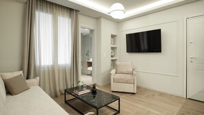 Uma sala de estar moderna com um sofá, uma mesa de centro, uma poltrona, uma televisão e uma porta.