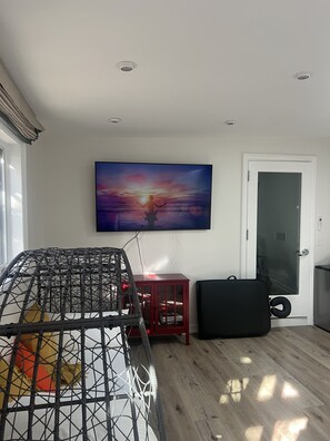 Relax in this stylish living room with a large flat-screen TV, comfortable sofa, and exercise ball.