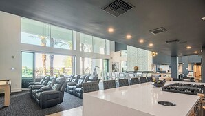A spacious living area with a large island, leather sofas, and a kitchen area with a stove. - Heated Pool | Near Mayo | Rooftop Deck | Hot Tub | Parking (Phoenix)