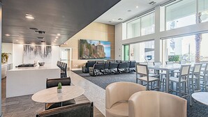 A modern hotel lobby with a central island, seating areas, and large windows offering views. - Heated Pool | Near Mayo | Rooftop Deck | Hot Tub | Parking (Phoenix)