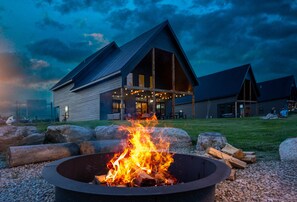 A modern building with a large fire pit in the foreground.