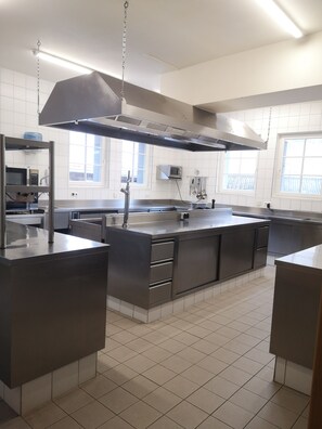 Una cocina moderna con electrodomésticos de acero inoxidable, una isla grande y mucha luz natural que entra por las ventanas.