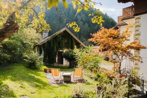 A rustic cabin with a sloped roof, surrounded by lush greenery and a well-maintained garden. - Holiday home for groups up to 27 guests right in the middle of the Alps! (Oberdrauburg)