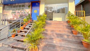 A spa entrance with a signboard, a staircase, and potted plants. - The Prime Hotel HBR (Bengaluru)