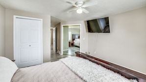 A bedroom with a bed, a ceiling fan, a TV mounted on the wall, and a door. - 5 Mi to Keystone Resort: Mountain-View Townhome! (Dillon)