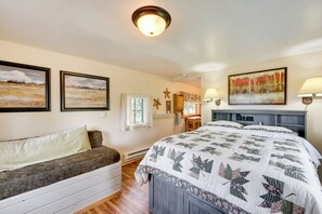 Ein gemütliches Schlafzimmer mit einem großen Bett, einer Couch und zwei Bildern an der Wand.