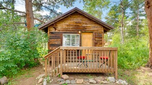 A rustic cabin with a wooden deck, a single door, and a window. - 'Minnehaha' Allenspark Cabin Near Hiking! (Allenspark)